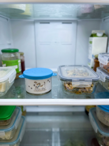 Opened wet dog food can covered with a lid for refrigerator storage.